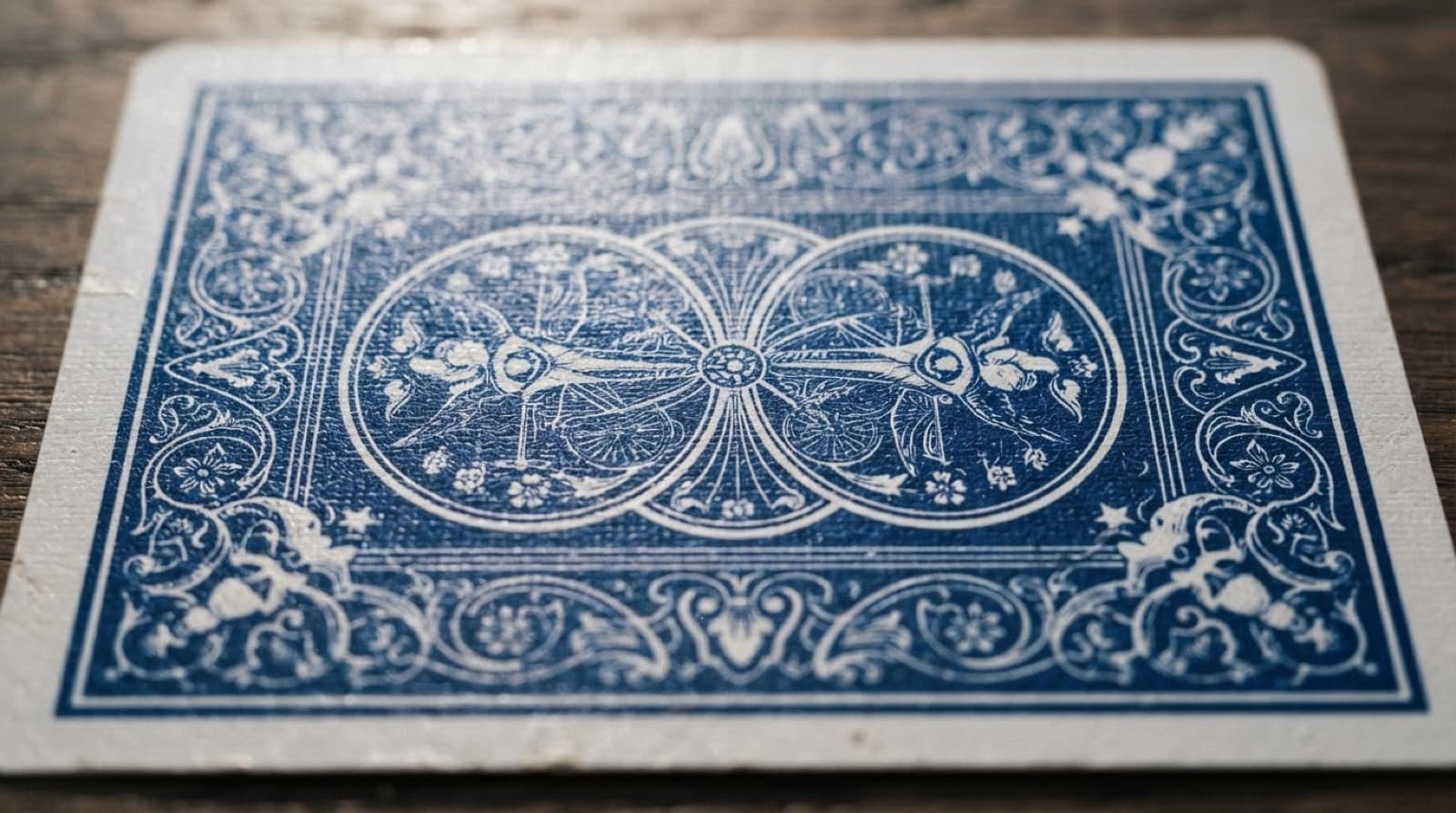 Gros plan macro sur le dos bleu à motif filigrané d'une carte à jouer Bicycle posée sur du bois