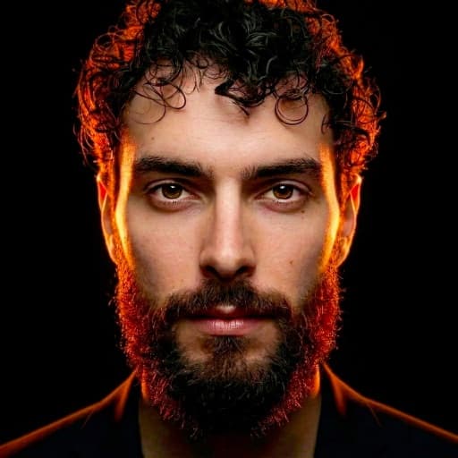 Sébastien Pieta, magicien professionnel, portrait aux reflets orange sur fond noir