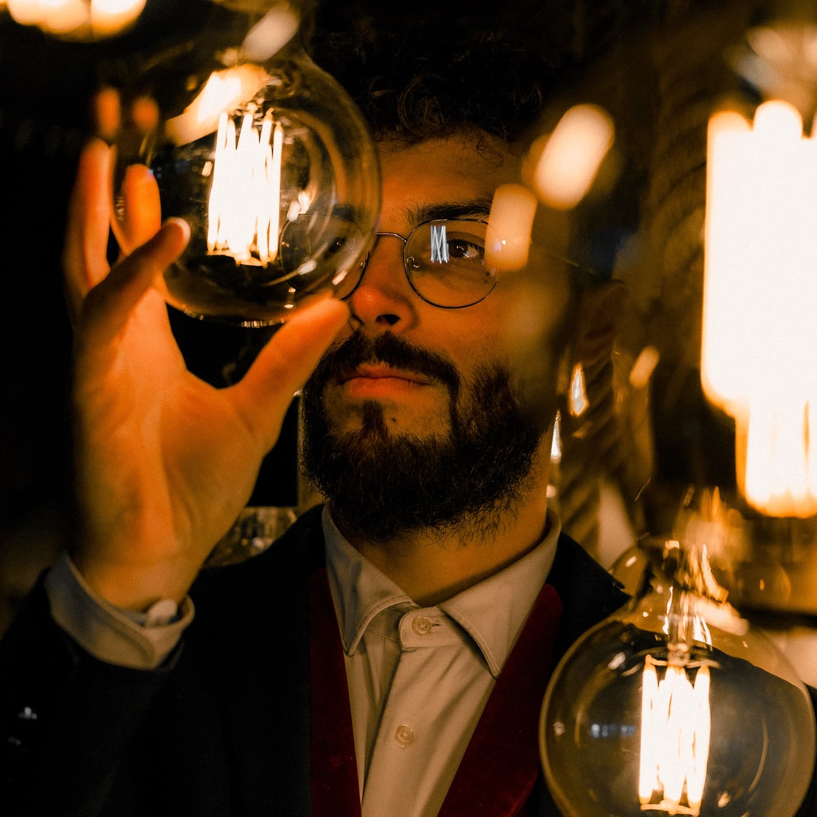 Sébastien Pieta, magicien professionnel, observant une ampoule à filament allumée