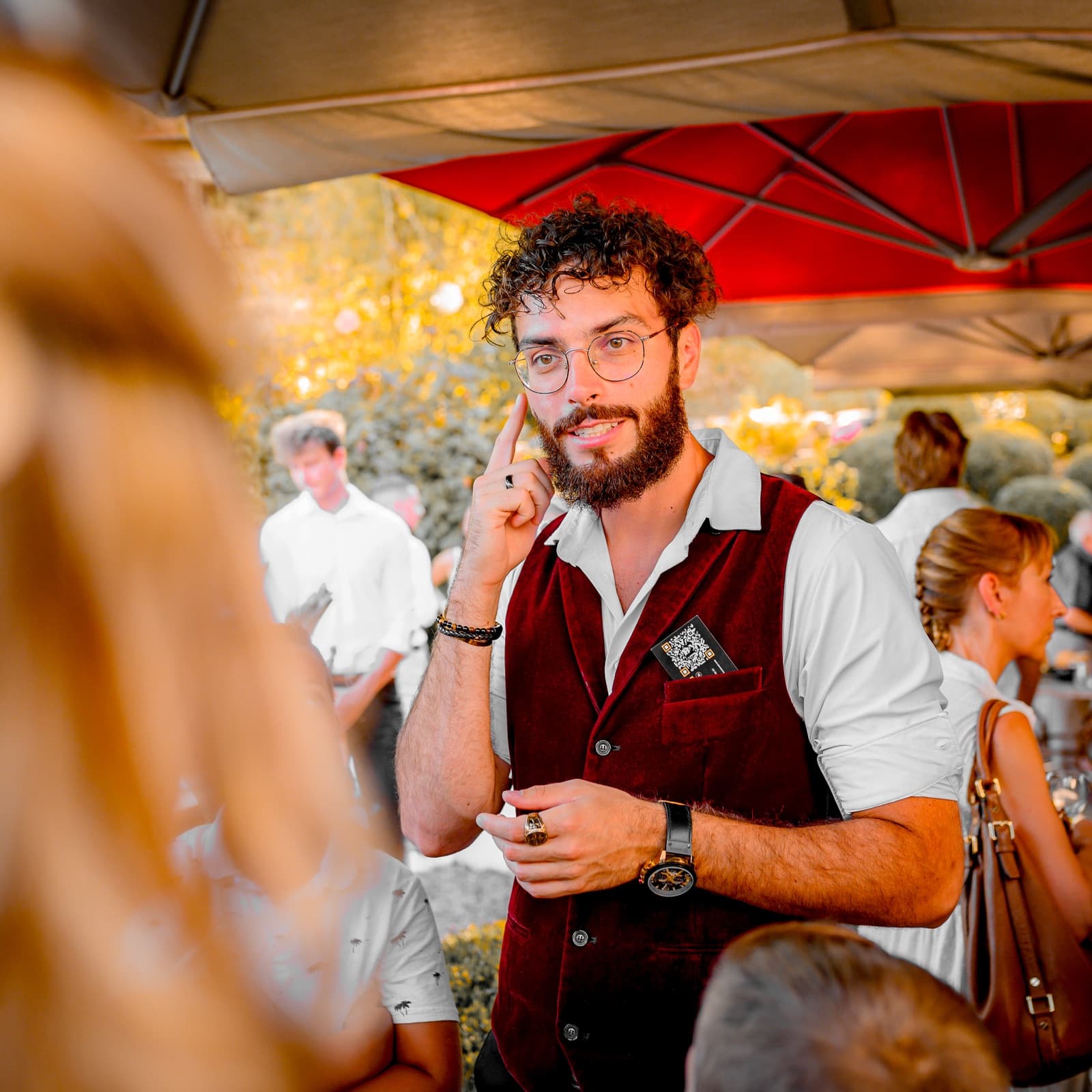 Sébastien Pieta, magicien professionnel, l'index sur la tempe pendant une séquence de mentalisme sous les parasols d'une réception